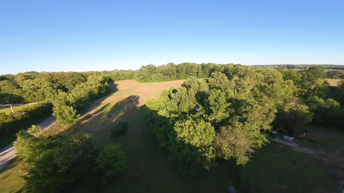 Golden-hour aerial view of field and timber at Walnut Grove